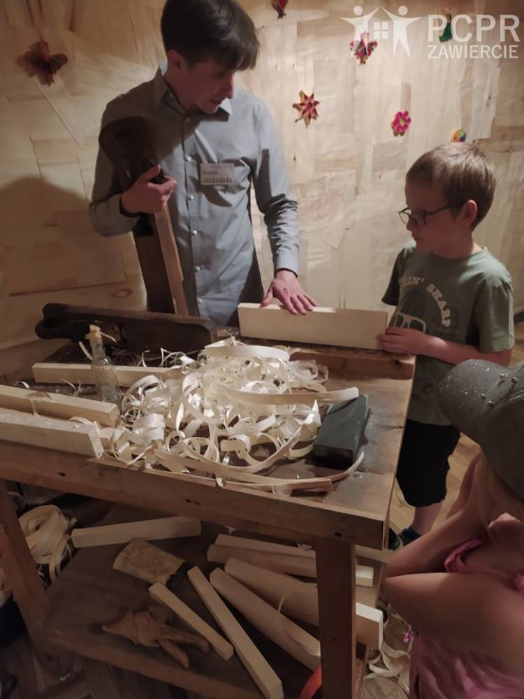 Zdjęcie: Mężczyzna uczy dzieci korzystać z narzędzi stolarskich